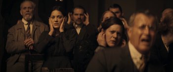 Movie still from “The Immigrant” (2013), directed by James Gray – A group of people standing around each other; Close Up shot, Over the shoulder angle