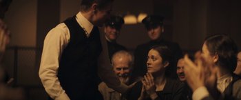 Movie still from “The Immigrant” (2013), directed by James Gray – A man and a woman in front of a group of people; Medium shot, Over the shoulder angle