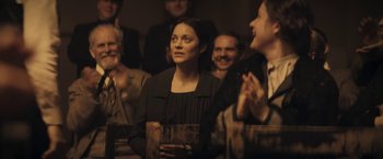 Movie still from “The Immigrant” (2013), directed by James Gray – A group of people standing in a room; Medium shot, Over the shoulder angle