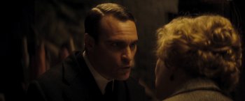 Movie still from “The Immigrant” (2013), directed by James Gray – A person wearing a suit and tie; Close Up shot, Over the shoulder angle