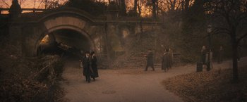Movie still from “The Immigrant” (2013), directed by James Gray – A group of people walking on a path near a tunnel; Extreme Wide shot, High angle