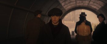 Movie still from “The Immigrant” (2013), directed by James Gray – A young man in a hat and a coat; Medium shot, Low angle