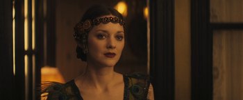 Movie still from “The Immigrant” (2013), directed by James Gray – A woman wearing a headpiece with peacock feathers on her head; Close Up shot, Over the shoulder angle