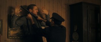 Movie still from “The Immigrant” (2013), directed by James Gray – A police officer holding a man up to his chest; Medium shot, Over the shoulder angle