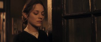 Movie still from “The Immigrant” (2013), directed by James Gray – A woman in a black dress is standing in front of a window; Close Up shot, Low angle
