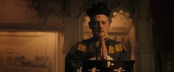Movie still from “The Immigrant” (2013), directed by James Gray – An older man in a black hat and a green robe; Medium shot, Low angle