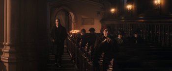 Movie still from “The Immigrant” (2013), directed by James Gray – A group of people sitting in a room next to a row of pews; Wide shot, Low angle