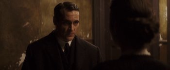 Movie still from “The Immigrant” (2013), directed by James Gray – A man wearing a suit and tie looking at his reflection in a mirror; Close Up shot, Over the shoulder angle