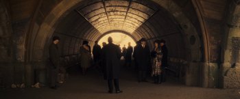 Movie still from “The Immigrant” (2013), directed by James Gray – A group of people standing inside of an underground tunnel; Wide shot, High angle