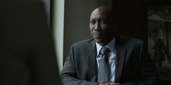 Movie still from “House of Cards” (2013), created by Beau Willimon – A man wearing a suit and tie sitting in a room; Close Up shot, Over the shoulder angle