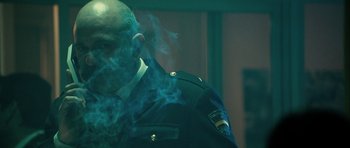 Movie still from “The Imposter” (2012), directed by Bart Layton – A man in a military uniform smoking a cigarette; Medium shot, Low angle