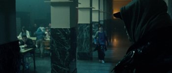 Movie still from “The Imposter” (2012), directed by Bart Layton – A person walking down the stairs in a building; Medium shot, Over the shoulder angle