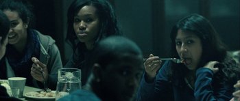 Movie still from “The Imposter” (2012), directed by Bart Layton – A group of people sitting around a table; Medium shot, Over the shoulder angle