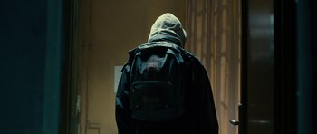 Movie still from “The Imposter” (2012), directed by Bart Layton – A person with a backpack is standing in a room; Medium shot, Low angle