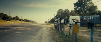 Movie still from “The Imposter” (2012), directed by Bart Layton – A row of mailboxes on the side of the road; Extreme Wide shot, Low angle