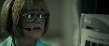 Movie still from “The Imposter” (2012), directed by Bart Layton – A woman wearing glasses and a blue shirt; Close Up shot, Over the shoulder angle