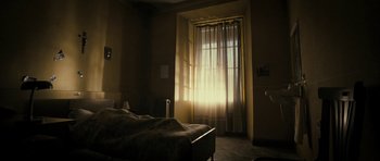 Movie still from “The Imposter” (2012), directed by Bart Layton – A bed room with a bed and a large window; Wide shot, Low angle