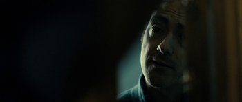 Movie still from “The Imposter” (2012), directed by Bart Layton – A man's face in the dark; Close Up shot, Over the shoulder angle