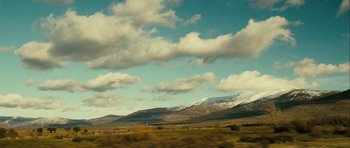 Movie still from “The Imposter” (2012), directed by Bart Layton – A view of a mountain range from a car window; Extreme Wide shot, Low angle