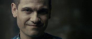 Movie still from “The Imposter” (2012), directed by Bart Layton – A man's face in a dimly - lit room; Close Up shot, Over the shoulder angle
