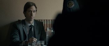 Movie still from “The Imposter” (2012), directed by Bart Layton – A man sitting at a table in front of another man; Close Up shot, Over the shoulder angle