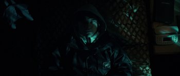 Movie still from “The Imposter” (2012), directed by Bart Layton – A man wearing a hooded jacket in the dark; Close Up shot, High angle