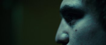 Movie still from “The Imposter” (2012), directed by Bart Layton – A man's face with dark makeup; Extreme Close Up shot, Low angle
