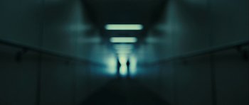 Movie still from “The Imposter” (2012), directed by Bart Layton – Two people are walking down a hallway in a building; Extreme Wide shot, Low angle
