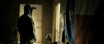 Movie still from “The Imposter” (2012), directed by Bart Layton – A person in a room next to a window with blinds closed; Medium shot, Low angle