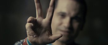 Movie still from “The Imposter” (2012), directed by Bart Layton – A man's hand making a hand sign; Extreme Close Up shot, Overhead angle