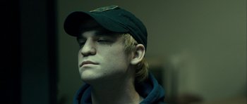 Movie still from “The Imposter” (2012), directed by Bart Layton – A young man with a cap is looking to his left; Close Up shot, Low angle