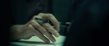 Movie still from “The Imposter” (2012), directed by Bart Layton – An older man holding a pen in his hand; Extreme Close Up shot, High angle