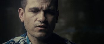 Movie still from “The Imposter” (2012), directed by Bart Layton – A man's face in a darkened room; Close Up shot, Over the shoulder angle