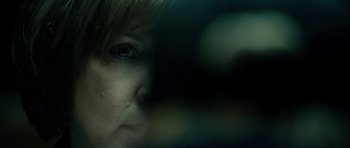 Movie still from “The Imposter” (2012), directed by Bart Layton – A woman's face in the dark; Extreme Close Up shot, Over the shoulder angle