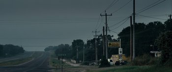 Movie still from “The Imposter” (2012), directed by Bart Layton – A road with power lines on the side of the road; Extreme Wide shot, Low angle