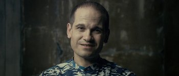 Movie still from “The Imposter” (2012), directed by Bart Layton – A person smiling for the camera; Close Up shot, High angle