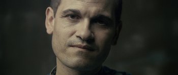 Movie still from “The Imposter” (2012), directed by Bart Layton – A man's face in a dimly - lit room; Close Up shot, Over the shoulder angle