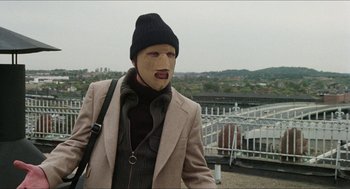 Movie still from “The In-Laws” (1979), directed by Arthur Hiller – A man wearing a mask and a jacket; Medium shot, Low angle