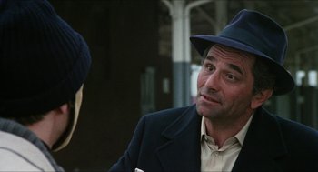 Movie still from “The In-Laws” (1979), directed by Arthur Hiller – A man wearing a hat and a suit; Close Up shot, Over the shoulder angle