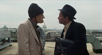Movie still from “The In-Laws” (1979), directed by Arthur Hiller – Two men in hats and suits talking to each other; Close Up shot, Over the shoulder angle