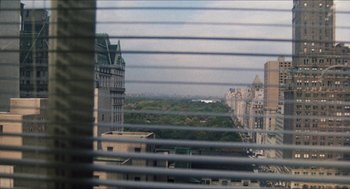 Movie still from “The In-Laws” (1979), directed by Arthur Hiller – A view of a city from a window with blinds; Extreme Wide shot, High angle
