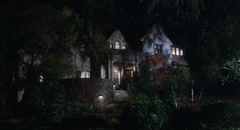 Movie still from “The In-Laws” (1979), directed by Arthur Hiller – A house that is lit up at night time; Extreme Wide shot, Low angle