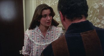 Movie still from “The In-Laws” (1979), directed by Arthur Hiller – A woman in a patterned nightgown talking to a man in a brown jacket; Medium shot, Over the shoulder angle