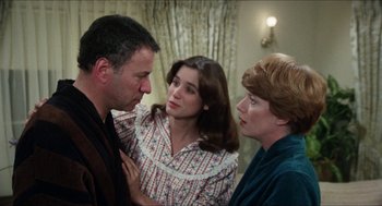Movie still from “The In-Laws” (1979), directed by Arthur Hiller – Two women and a man are talking to each other; Medium shot, Over the shoulder angle