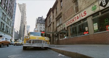 Movie still from “The In-Laws” (1979), directed by Arthur Hiller – A taxi cab is parked on the side of the street; Extreme Wide shot, Low angle