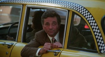 Movie still from “The In-Laws” (1979), directed by Arthur Hiller – A man in a suit sitting in the drivers seat of a taxi cab; Medium shot, Low angle