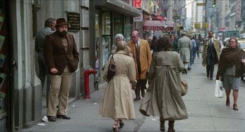 Movie still from “The In-Laws” (1979), directed by Arthur Hiller – A group of people walking down a sidewalk; Wide shot, Over the shoulder angle