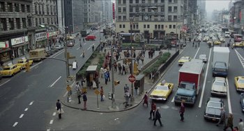Movie still from “The In-Laws” (1979), directed by Arthur Hiller – A busy city street filled with people and cars; Extreme Wide shot, High angle