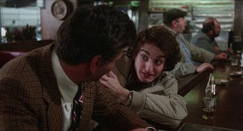 Movie still from “The In-Laws” (1979), directed by Arthur Hiller – A man and a woman sitting at a table talking to each other; Close Up shot, Over the shoulder angle