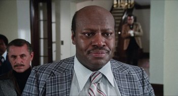 Movie still from “The In-Laws” (1979), directed by Arthur Hiller – A person wearing a suit and a tie; Close Up shot, Low angle